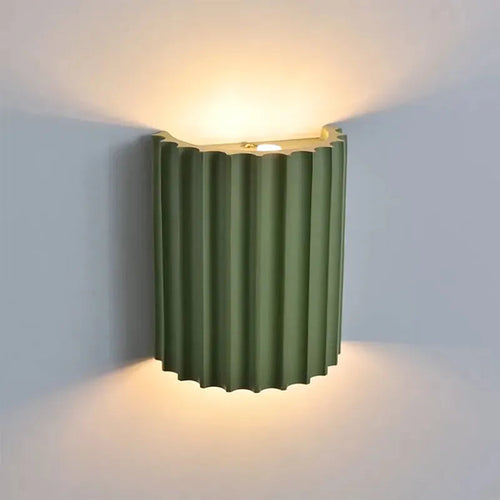 Luminária de parede em estilo minimalista com iluminação suave e formato inspirado em doces sofisticados para um toque contemporâneo na sua decoração.