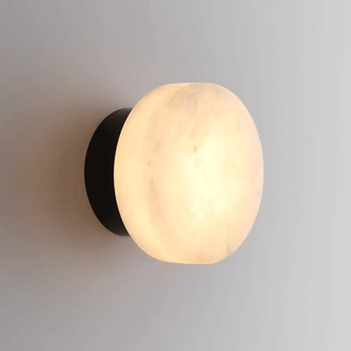 Luminária de parede em mármore contemporâneo com iluminação suave e difusa, ideal para complementar ambientes sofisticados. Padrão