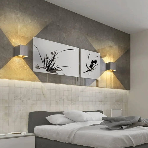 Luminária de parede em metal escovado com iluminação suave e design minimalista para ambientes sofisticados. Prata escovada