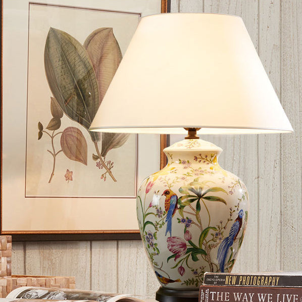 Luminária de mesa estilo retrô em cerâmica com design de flores e pássaros.