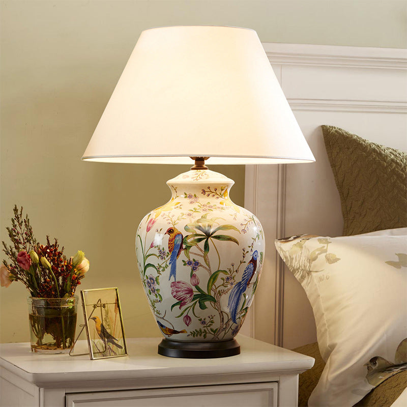 Luminária de mesa estilo retrô em cerâmica com design de flores e pássaros.