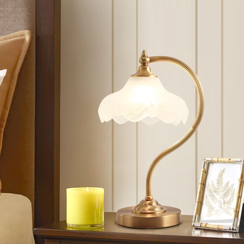 Luminária de mesa retro em metal dourado e vidro com cúpula em formato de pétalas.