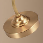 Luminária de mesa retro em metal dourado e vidro com cúpula em formato de pétalas.