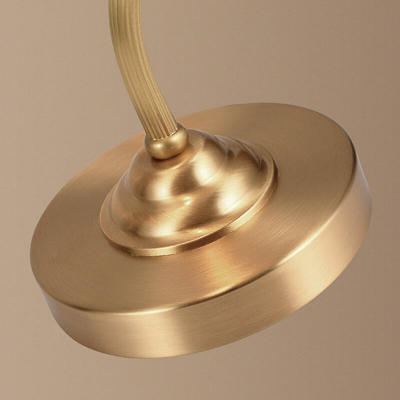 Luminária de mesa retro em metal dourado e vidro com cúpula em formato de pétalas.