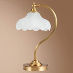 Luminária de mesa retro em metal dourado e vidro com cúpula em formato de pétalas.
