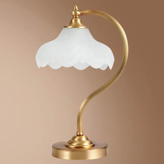 Luminária de mesa retro em metal dourado e vidro com cúpula em formato de pétalas.