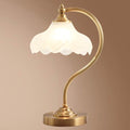 Luminária de mesa retro em metal dourado e vidro com cúpula em formato de pétalas.