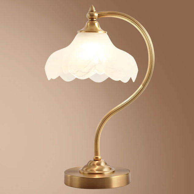 Luminária de mesa retro em metal dourado e vidro com cúpula em formato de pétalas.