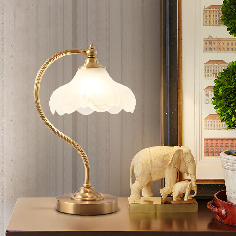 Luminária de mesa retro em metal dourado e vidro com cúpula em formato de pétalas.