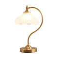 Luminária de mesa retro em metal dourado e vidro com cúpula em formato de pétalas.