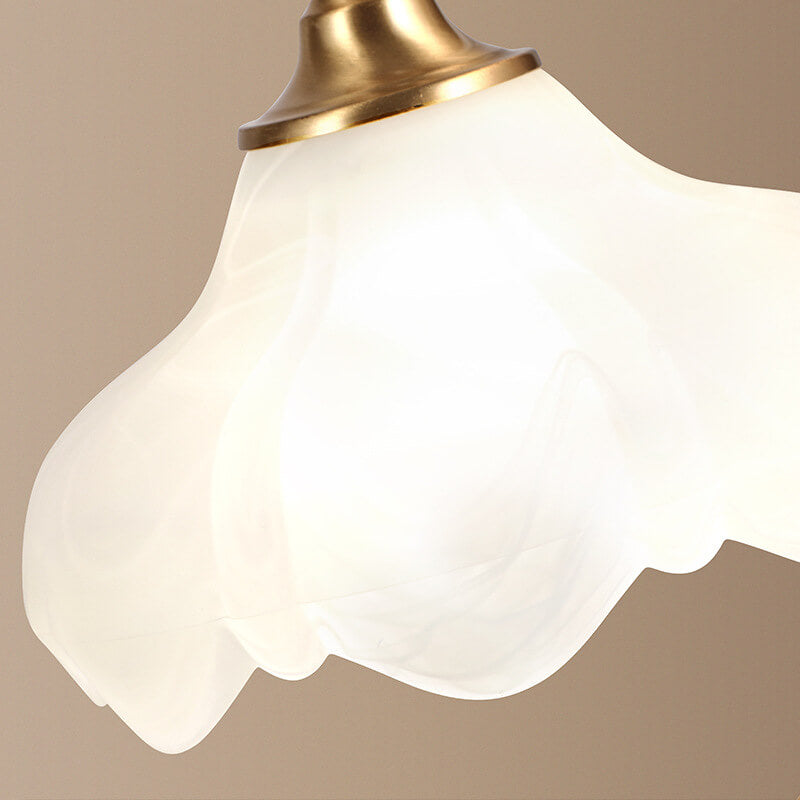 Luminária de mesa retro em metal dourado e vidro com cúpula em formato de pétalas.