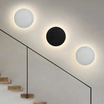 Luminária de parede LED circular com design minimalista e acabamento em aço escovado.