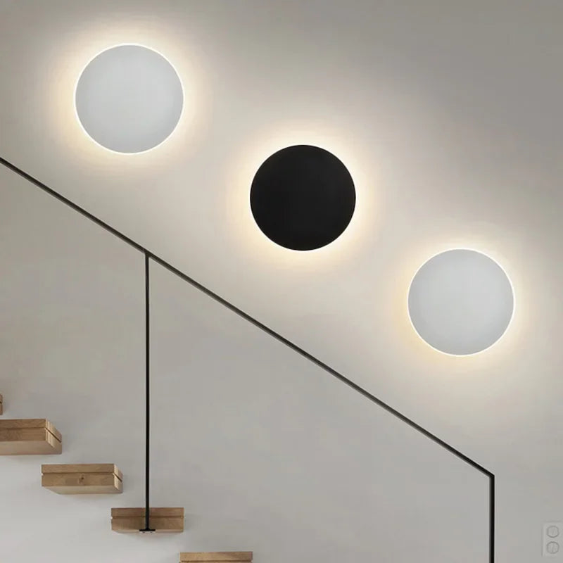 Luminária de parede LED circular com design minimalista e acabamento em aço escovado.