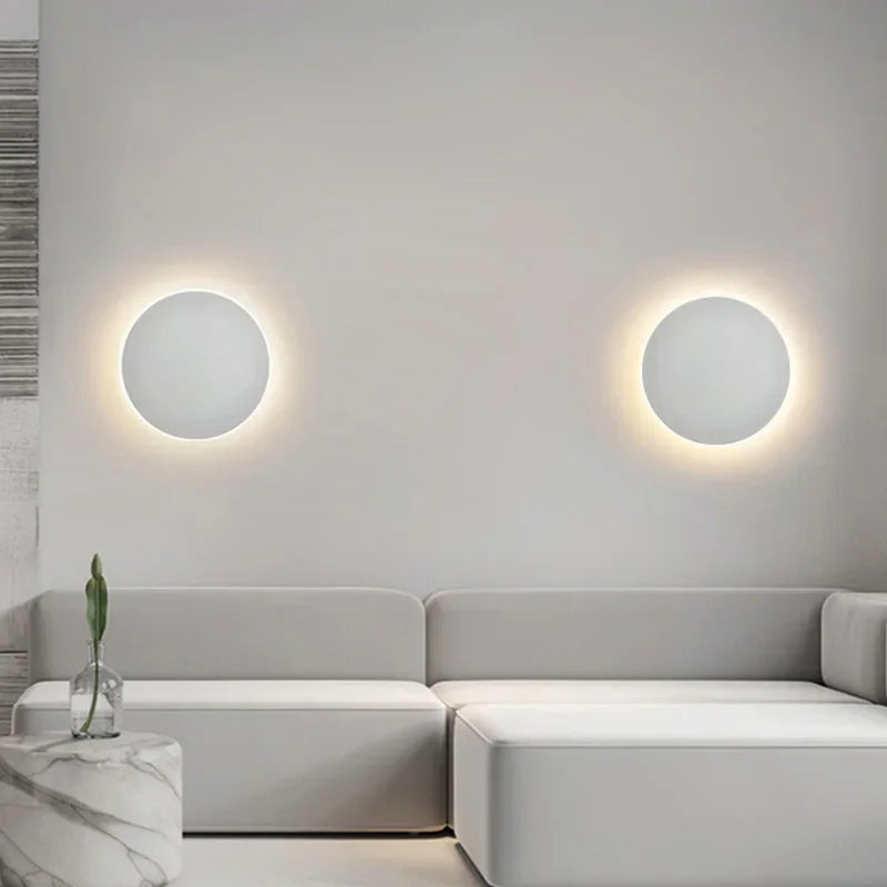 Luminária de parede LED circular com design minimalista e acabamento em aço escovado.