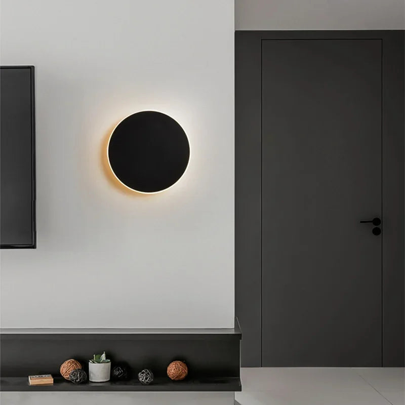 Luminária de parede LED circular com design minimalista e acabamento em aço escovado.