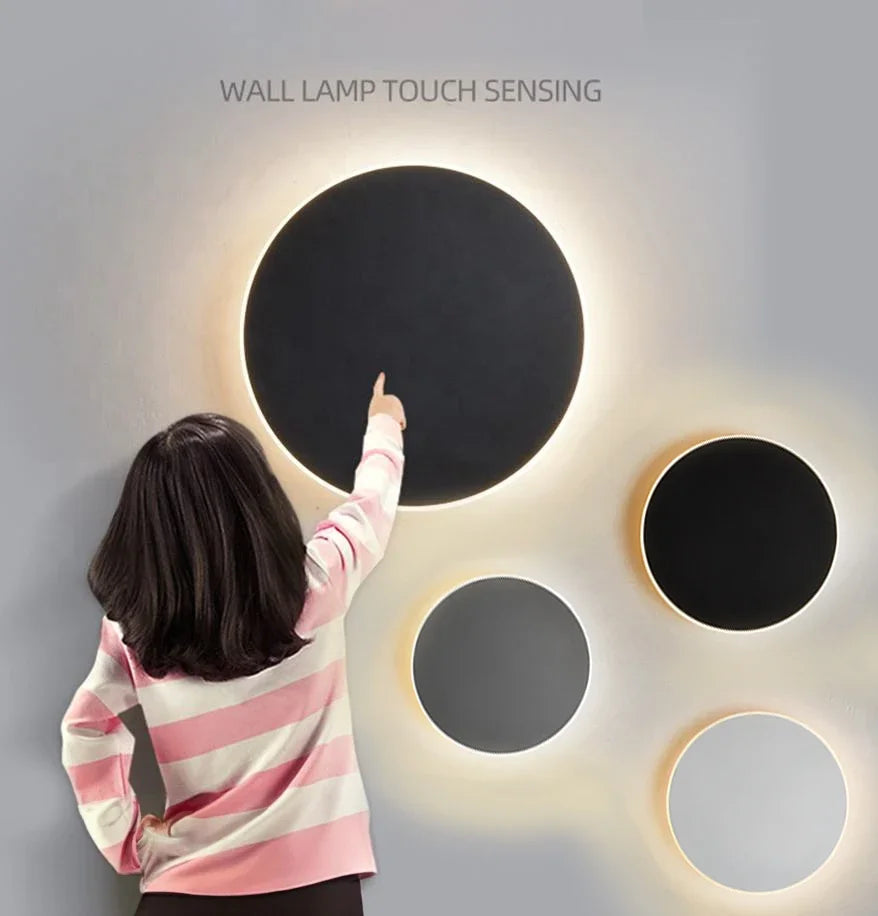 Luminária de parede LED circular com design minimalista e acabamento em aço escovado.