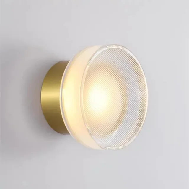 Luminária de parede circular contemporânea com iluminação difusa e acabamento minimalista em metal polido. Ouro