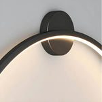 Luminária de parede em anel esculpido, com iluminação suave e design curvilíneo contemporâneo.