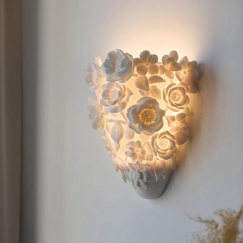 Luminária de parede em cerâmica artesanal com delicadas flores em relevo e iluminação suave para um toque de elegância e charme. Padrão