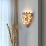 Luminária de parede em cerâmica artesanal com delicadas flores em relevo e iluminação suave para um toque de elegância e charme.