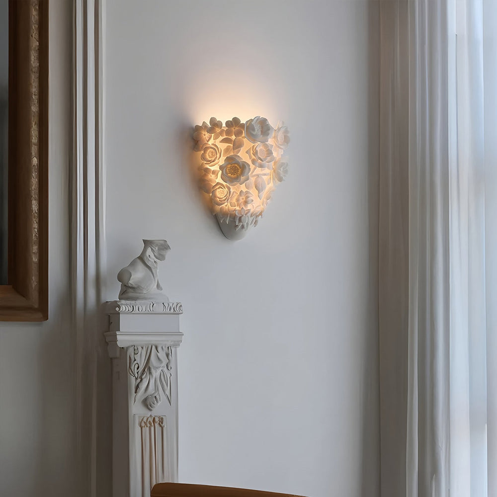Luminária de parede em cerâmica artesanal com delicadas flores em relevo e iluminação suave para um toque de elegância e charme.