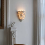 Luminária de parede em cerâmica artesanal com delicadas flores em relevo e iluminação suave para um toque de elegância e charme.