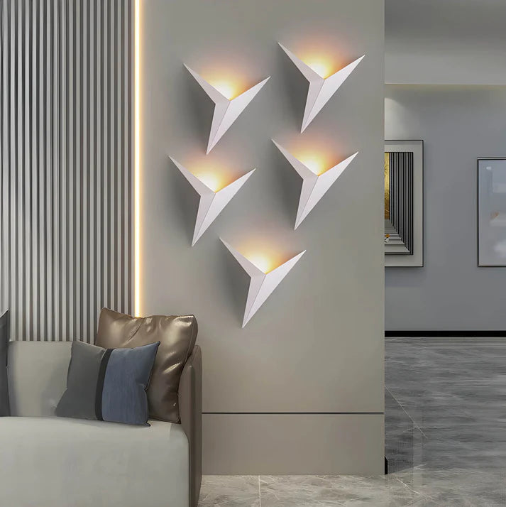 Luminária de parede em estilo contemporâneo, com iluminação suave e delicada em formato de pássaro, ideal para adornar ambientes modernos com charme e sofisticação. Branco