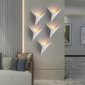 Luminária de parede em estilo contemporâneo, com iluminação suave e delicada em formato de pássaro, ideal para adornar ambientes modernos com charme e sofisticação. Branco