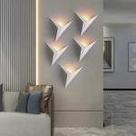 Luminária de parede em estilo contemporâneo, com iluminação suave e delicada em formato de pássaro, ideal para adornar ambientes modernos com charme e sofisticação. Branco