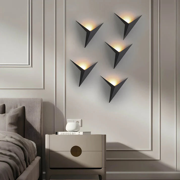 Luminária de parede em estilo contemporâneo, com iluminação suave e delicada em formato de pássaro, ideal para adornar ambientes modernos com charme e sofisticação.