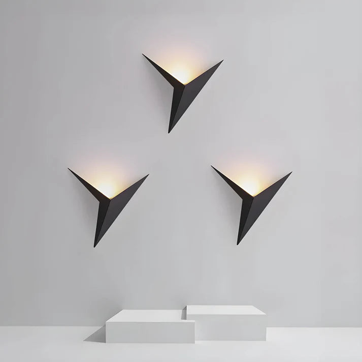 Luminária de parede em estilo contemporâneo, com iluminação suave e delicada em formato de pássaro, ideal para adornar ambientes modernos com charme e sofisticação.