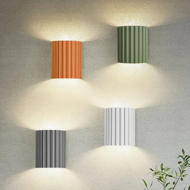 Luminária de parede em estilo minimalista com iluminação suave e formato inspirado em doces sofisticados para um toque contemporâneo na sua decoração.