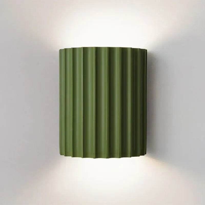 Luminária de parede em estilo minimalista com iluminação suave e formato inspirado em doces sofisticados para um toque contemporâneo na sua decoração.