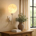 Luminária de parede em formato lunar com brilho suave e design contemporâneo para uma iluminação acolhedora. Usuário