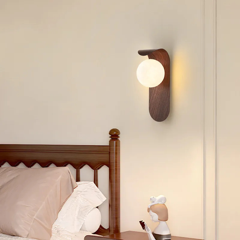 Luminária de parede em madeira de noz com luz suave e design escultural para ambientes sofisticados.