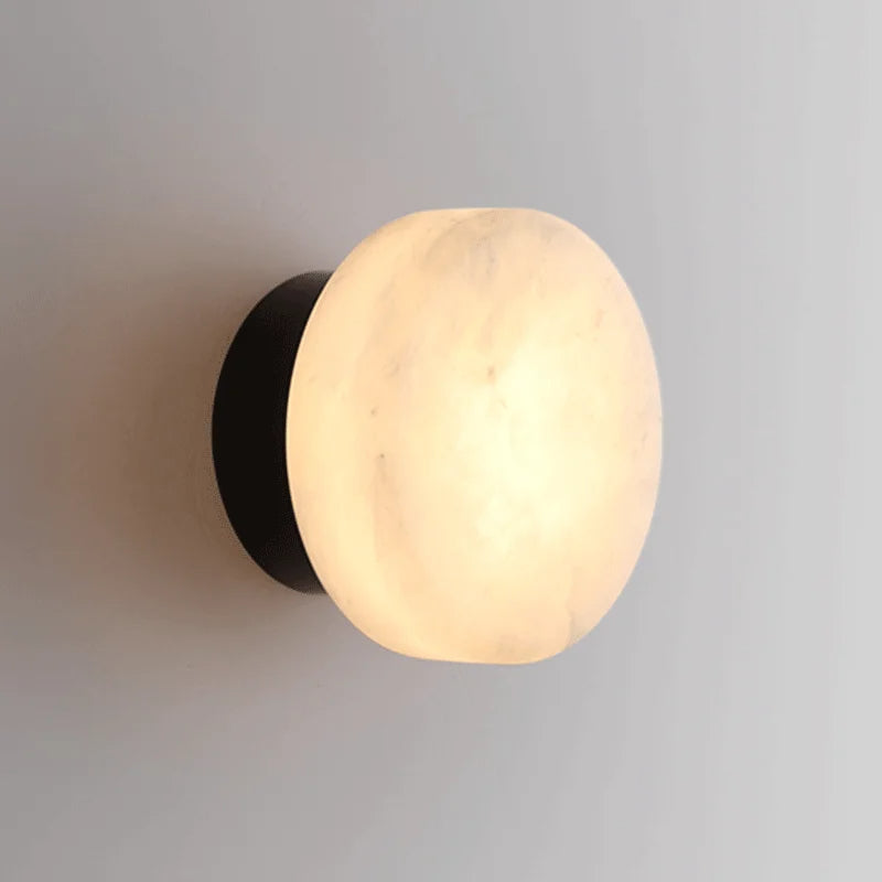 Luminária de parede em mármore contemporâneo com iluminação suave e difusa, ideal para complementar ambientes sofisticados. Padrão