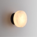 Luminária de parede em mármore contemporâneo com iluminação suave e difusa, ideal para complementar ambientes sofisticados.