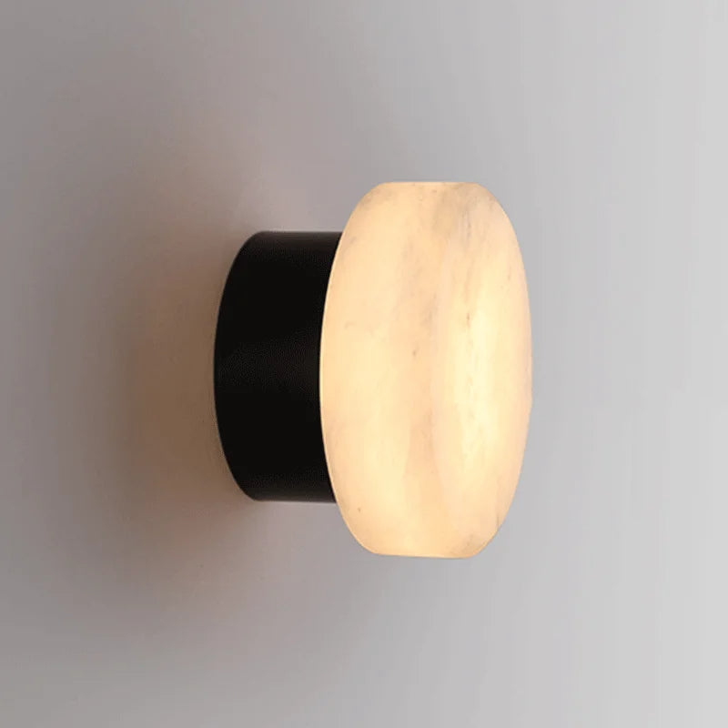 Luminária de parede em mármore contemporâneo com iluminação suave e difusa, ideal para complementar ambientes sofisticados.