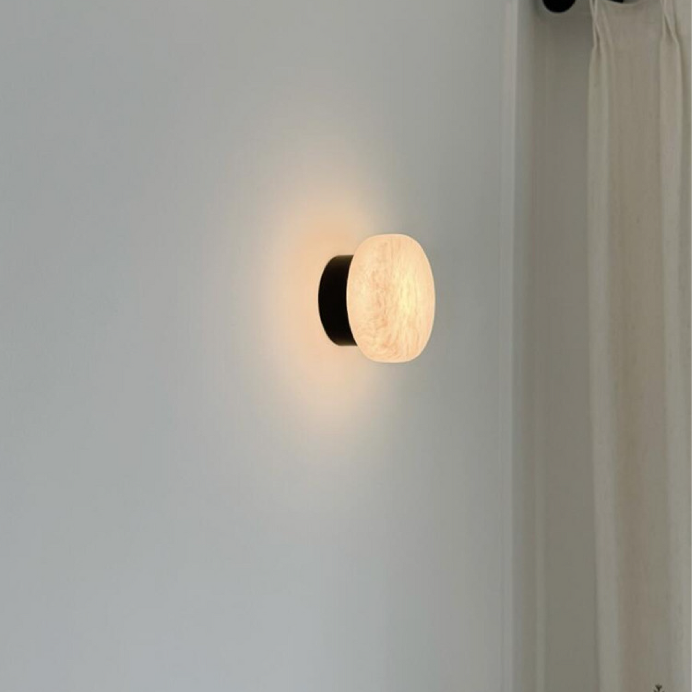 Luminária de parede em mármore contemporâneo com iluminação suave e difusa, ideal para complementar ambientes sofisticados.