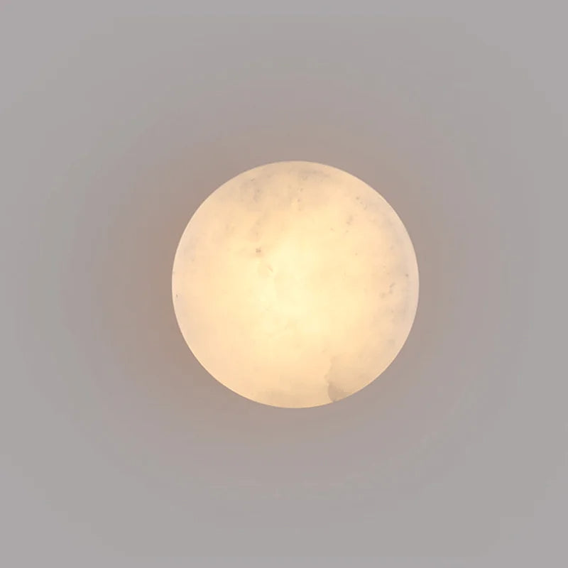 Luminária de parede em mármore contemporâneo com iluminação suave e difusa, ideal para complementar ambientes sofisticados.