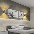 Luminária de parede em metal escovado com iluminação suave e design minimalista para ambientes sofisticados. Prata escovada