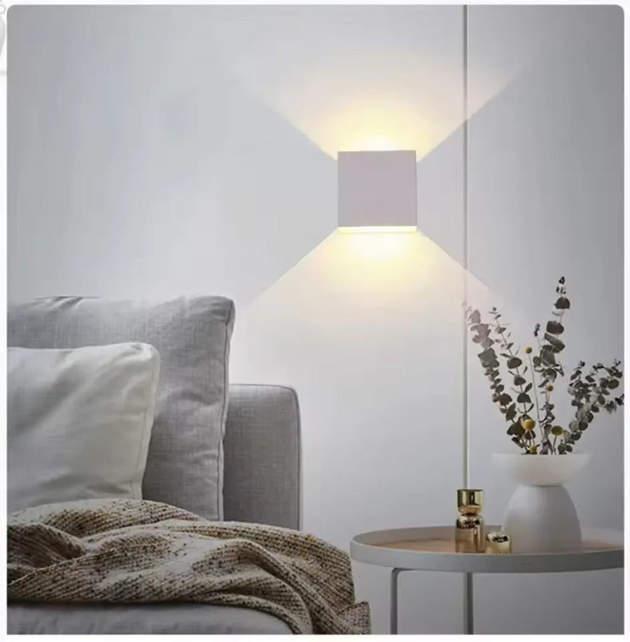 Luminária de parede em metal escovado com iluminação suave e design minimalista para ambientes sofisticados.