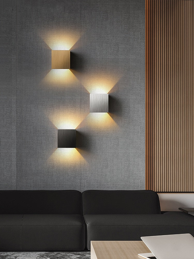 Luminária de parede em metal escovado com iluminação suave e design minimalista para ambientes sofisticados.