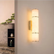 Luminária de parede em pedra refinada com iluminação suave e design escultórico contemporâneo.