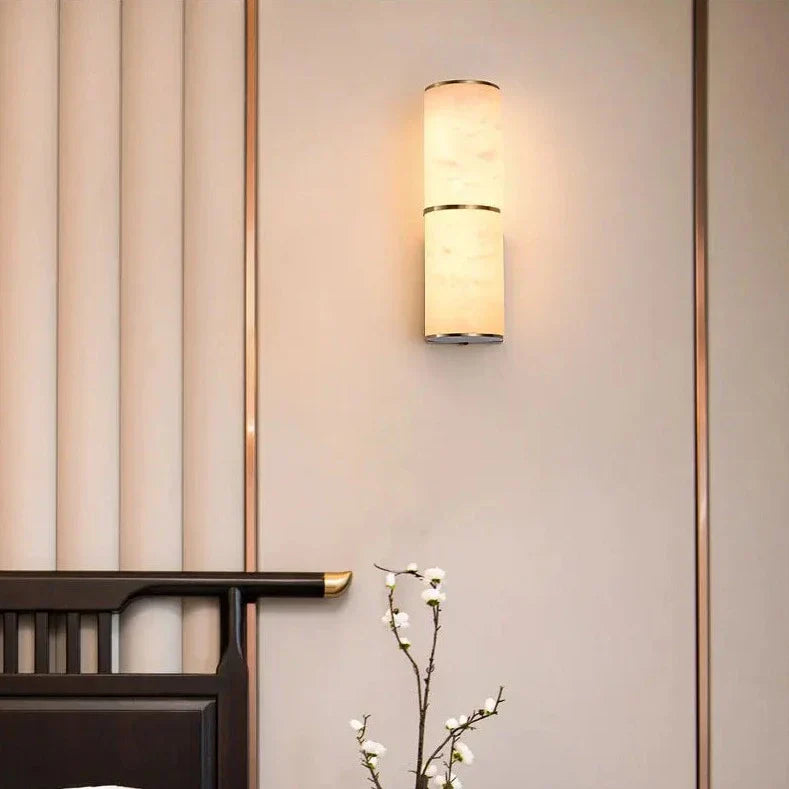 Luminária de parede em pedra refinada com iluminação suave e design escultórico contemporâneo.