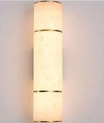 Luminária de parede em pedra refinada com iluminação suave e design escultórico contemporâneo.