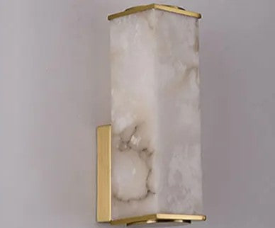 Luminária de parede em pedra refinada com iluminação suave e design escultórico contemporâneo.