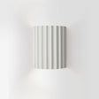 Luminária de parede em resina escultural, com iluminação suave e design contemporâneo, ideal para sofisticação de ambientes.