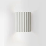 Luminária de parede em resina escultural, com iluminação suave e design contemporâneo, ideal para sofisticação de ambientes. Branco