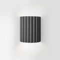 Luminária de parede em resina escultural, com iluminação suave e design contemporâneo, ideal para sofisticação de ambientes. Cinza